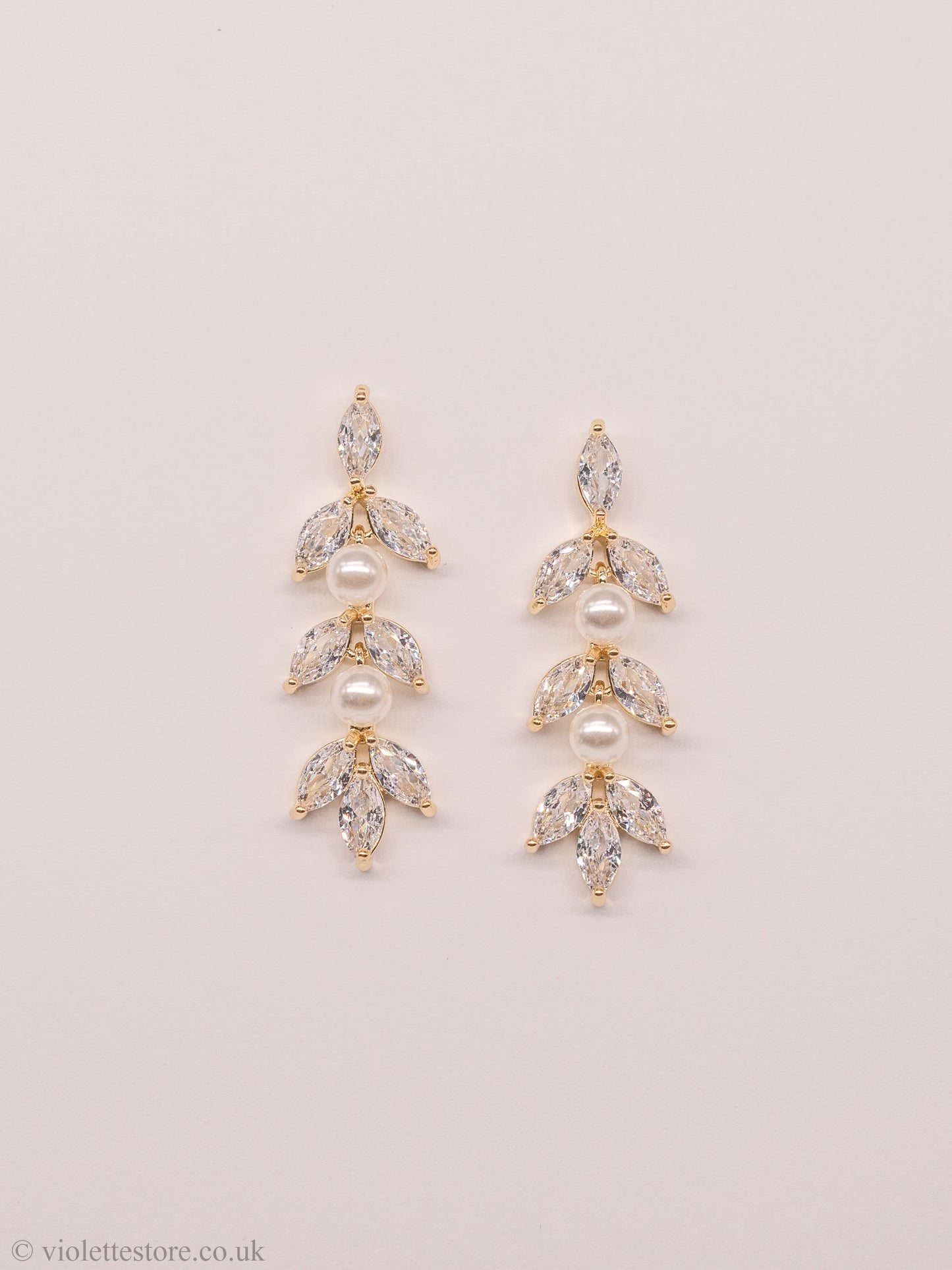 Gold & rose gold crystal earrings, a beautiful and elegant choice for both brides and bridesmaids. The style of these earrings allows them to dangle gracefully from the earlobe, catching the light and adding a touch of glamour to any wedding day look. The crystals and pearls are arranged in a beautiful design, creating a stunning visual effect.