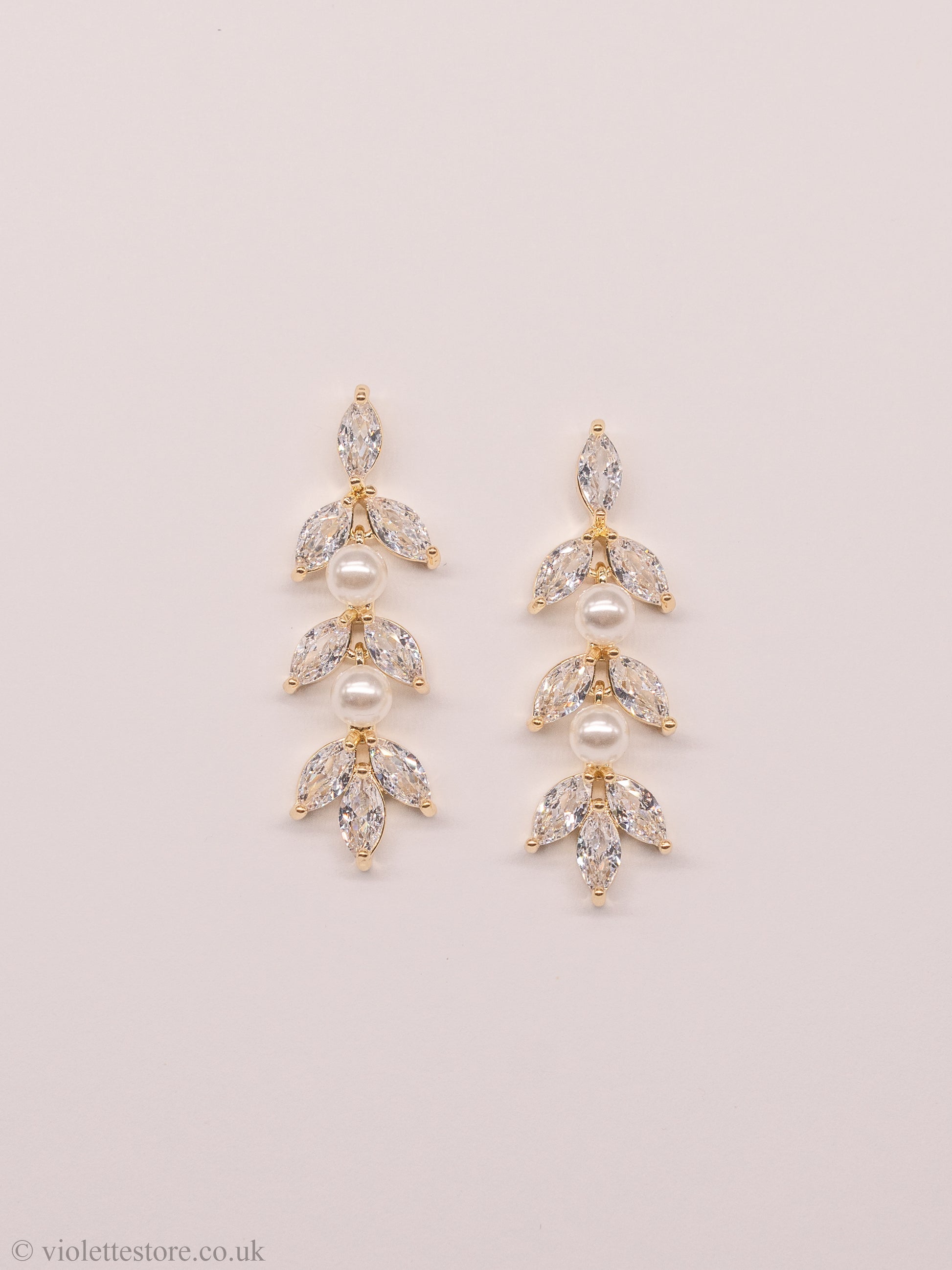 Gold & rose gold crystal earrings, a beautiful and elegant choice for both brides and bridesmaids. The style of these earrings allows them to dangle gracefully from the earlobe, catching the light and adding a touch of glamour to any wedding day look. The crystals and pearls are arranged in a beautiful design, creating a stunning visual effect.